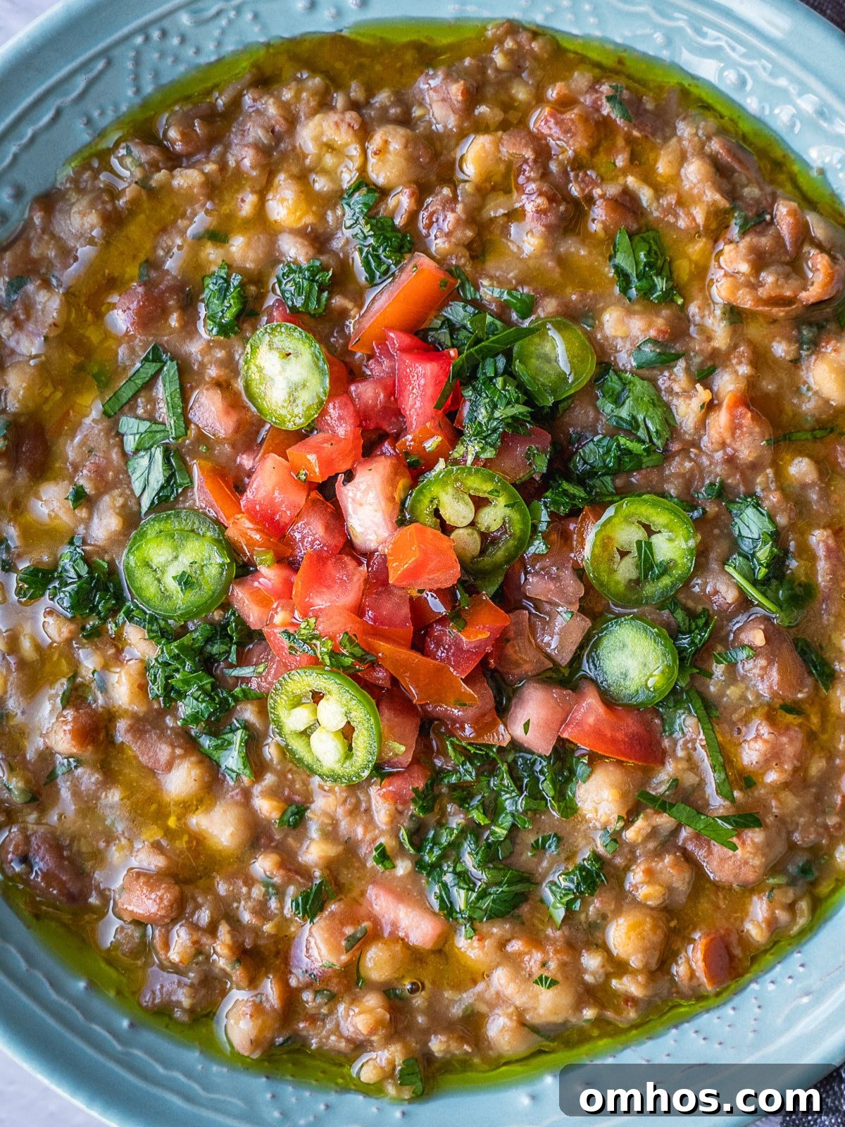 Bowl of ful medames garnished with more dressing.