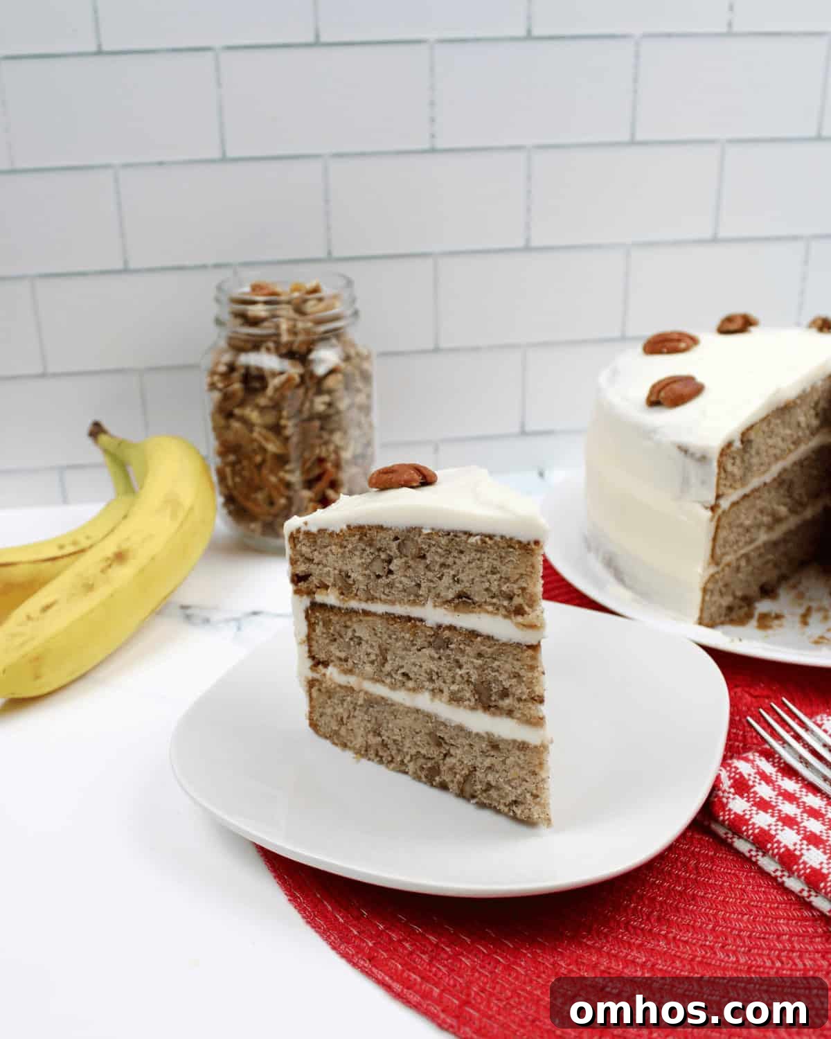 Old-Fashioned Hummingbird Cake Recipe 8 A slice of the Old fashioned hummingbird cake recipe with a whole cake in the background.