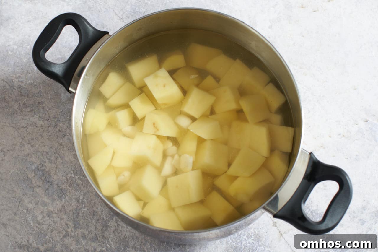 A large pot filled with water and cubed potatoes.