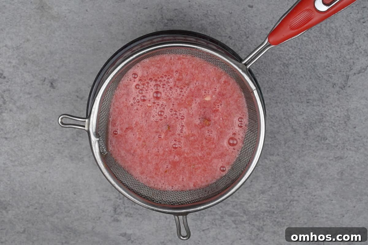 Refreshing Watermelon Mint Mojito Cocktail 5 Watermelon juice passing through a strainer.