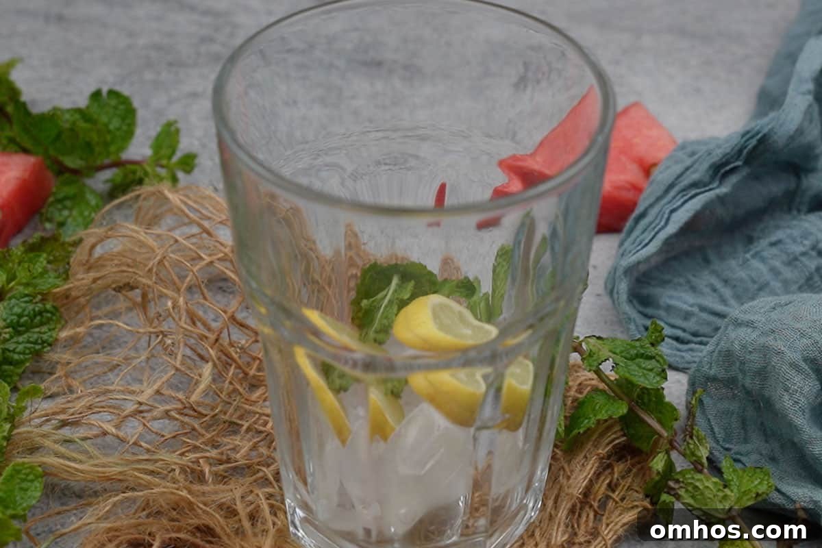 Refreshing Watermelon Mint Mojito Cocktail 10 Ice cubes, lemon slices and mint leaves added to the pitcher.