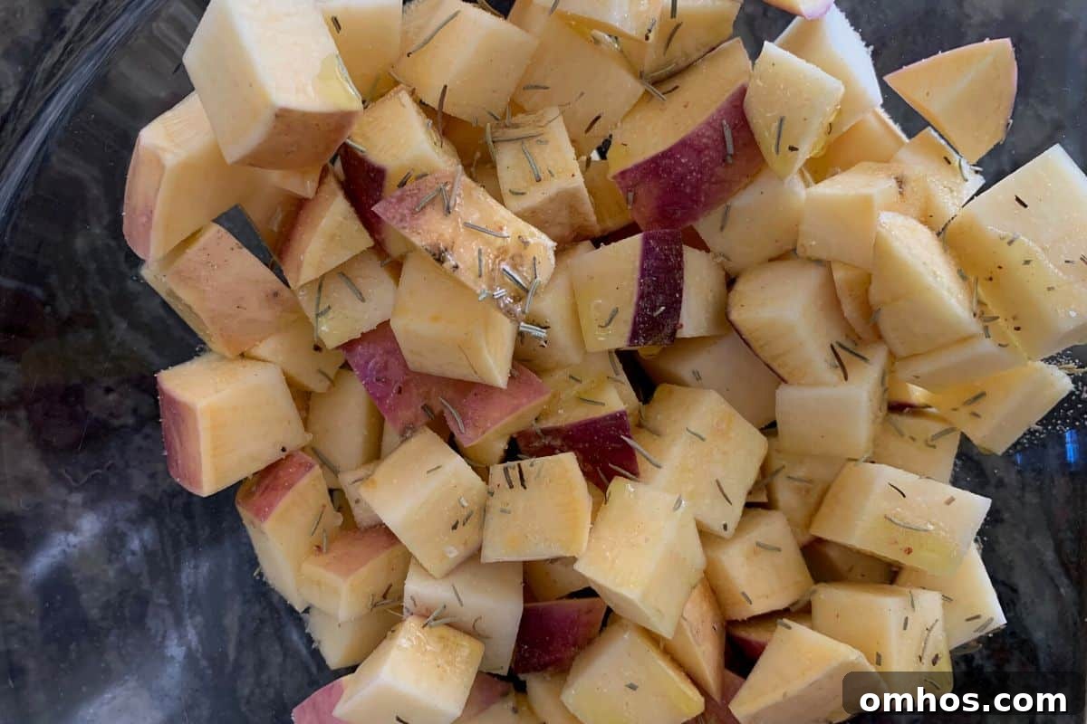 Crispy Air Fryer Rutabaga Fries 2 Cubed rutabagas with oil and dried herbs in a bowl.