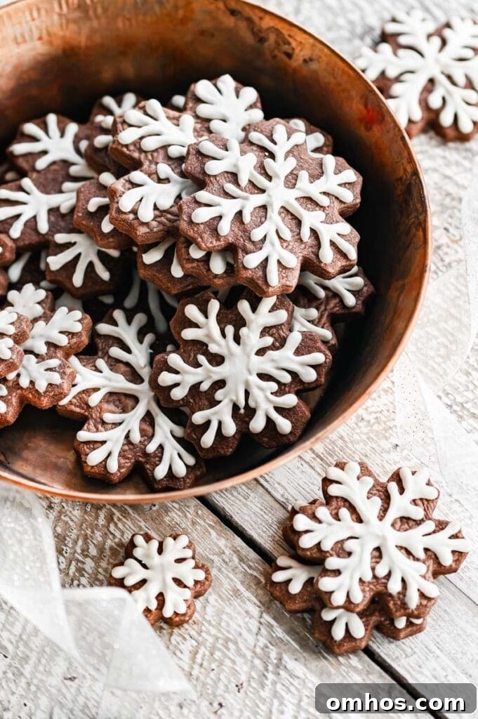 Copper bowl full of snowflake pipied chocolate sugar cookies.