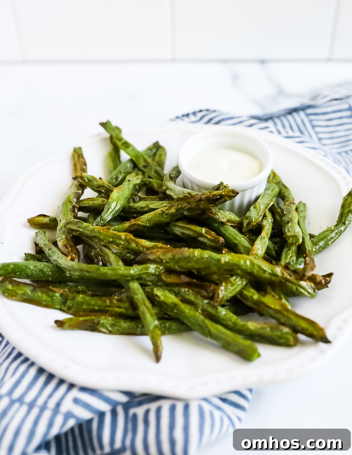 A white plate filled with air fryer green beans.