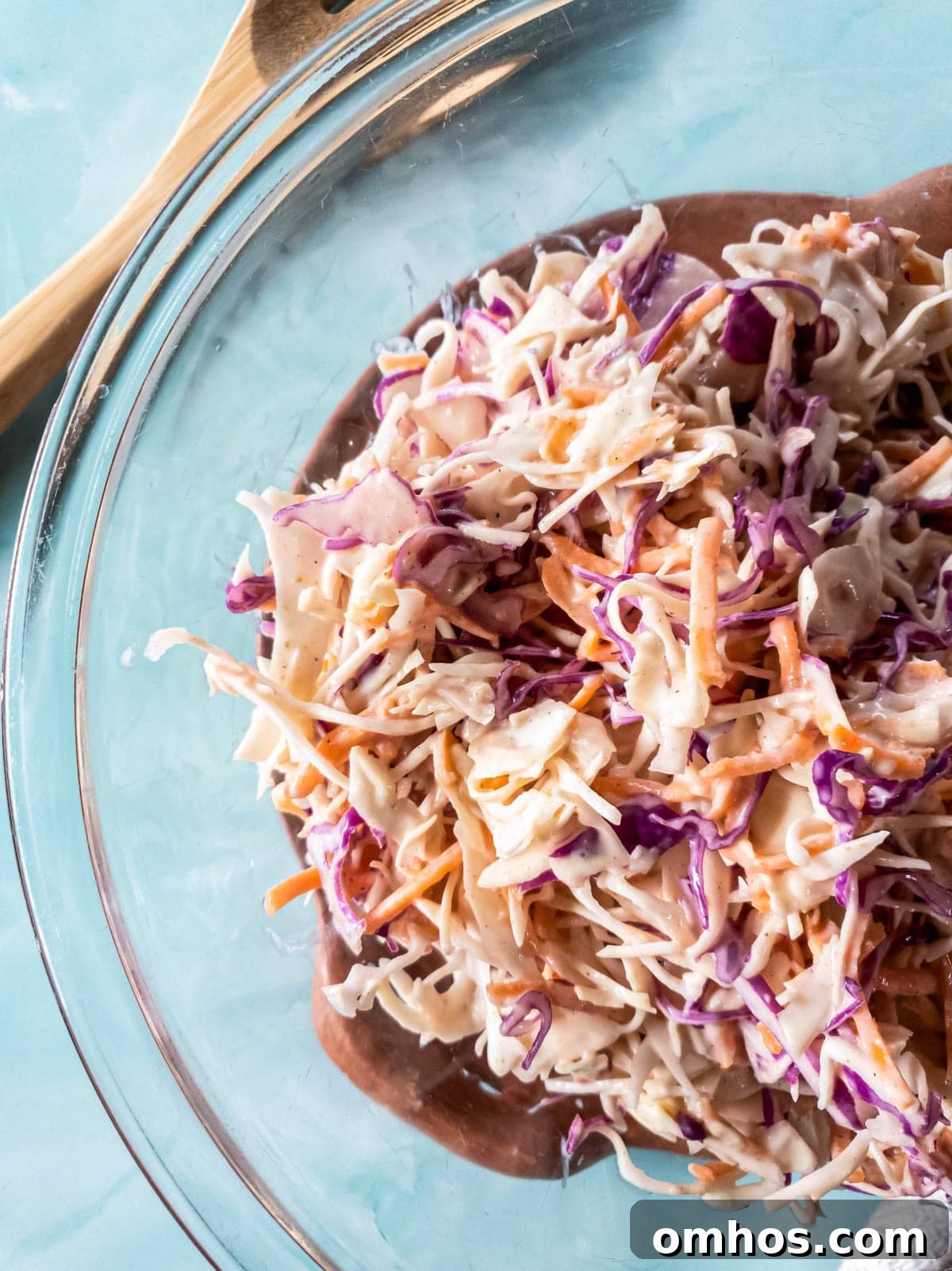 A picture of sugar-free coleslaw in glass bowl on blue background.