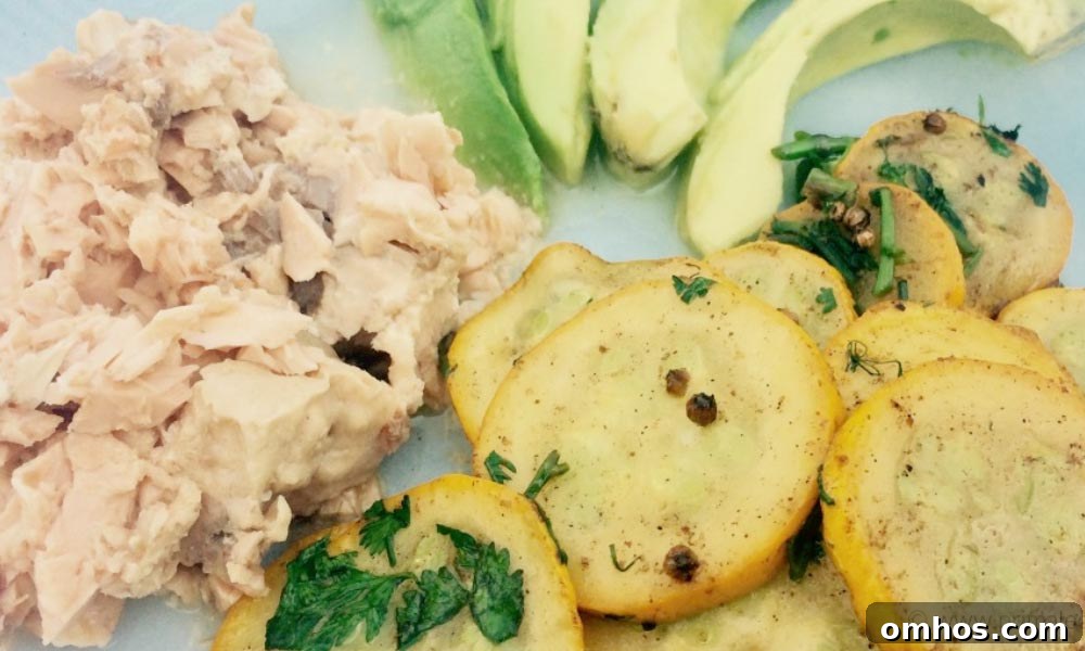 Salmon, avocado and slices of potatoes on a white surface.