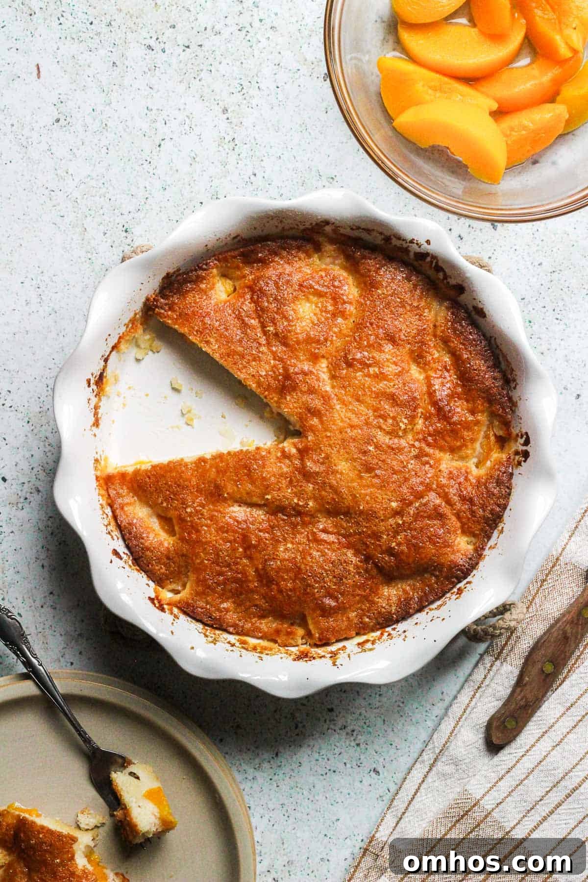Classic Southern Peach Cobbler Recipe 2 peach cobbler in a pie dish with sliced peaches