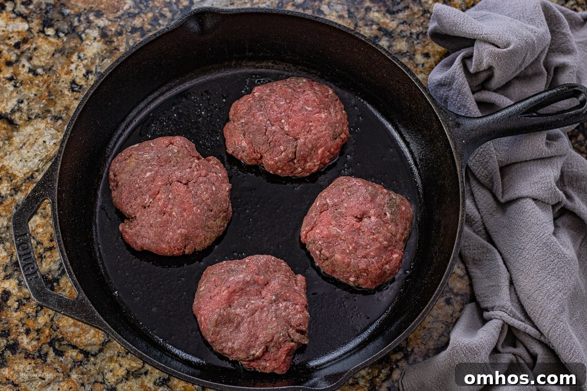 uncooked hamburger steaks in a cast iron skillet