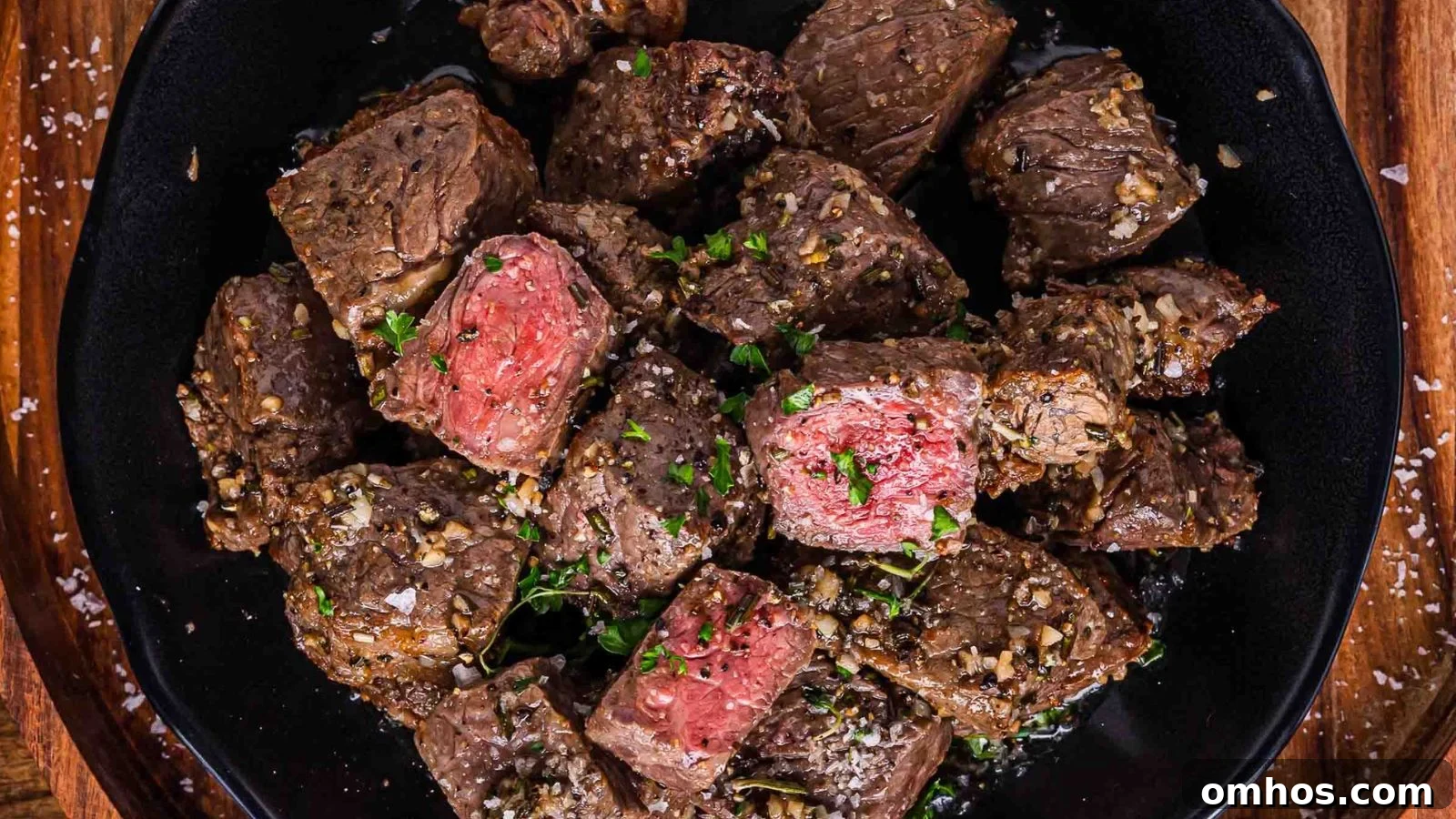 Air fryer steak bites coated in garlic butter served hot with crispy browned edges.