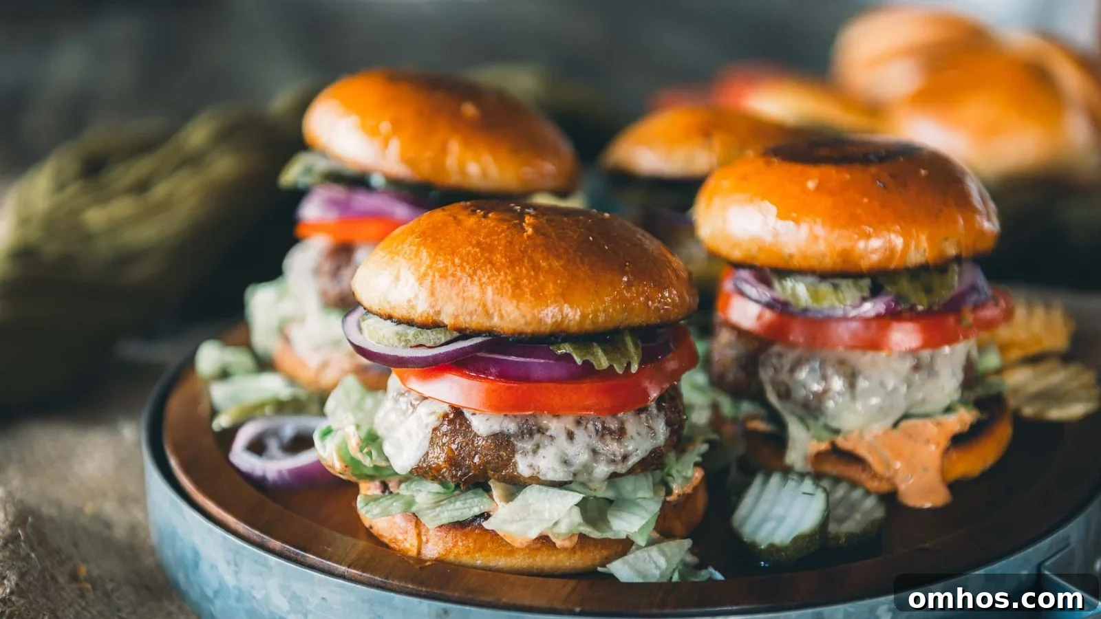 Air fryer turkey burgers with browned exteriors stacked with lettuce and toppings on toasted buns.