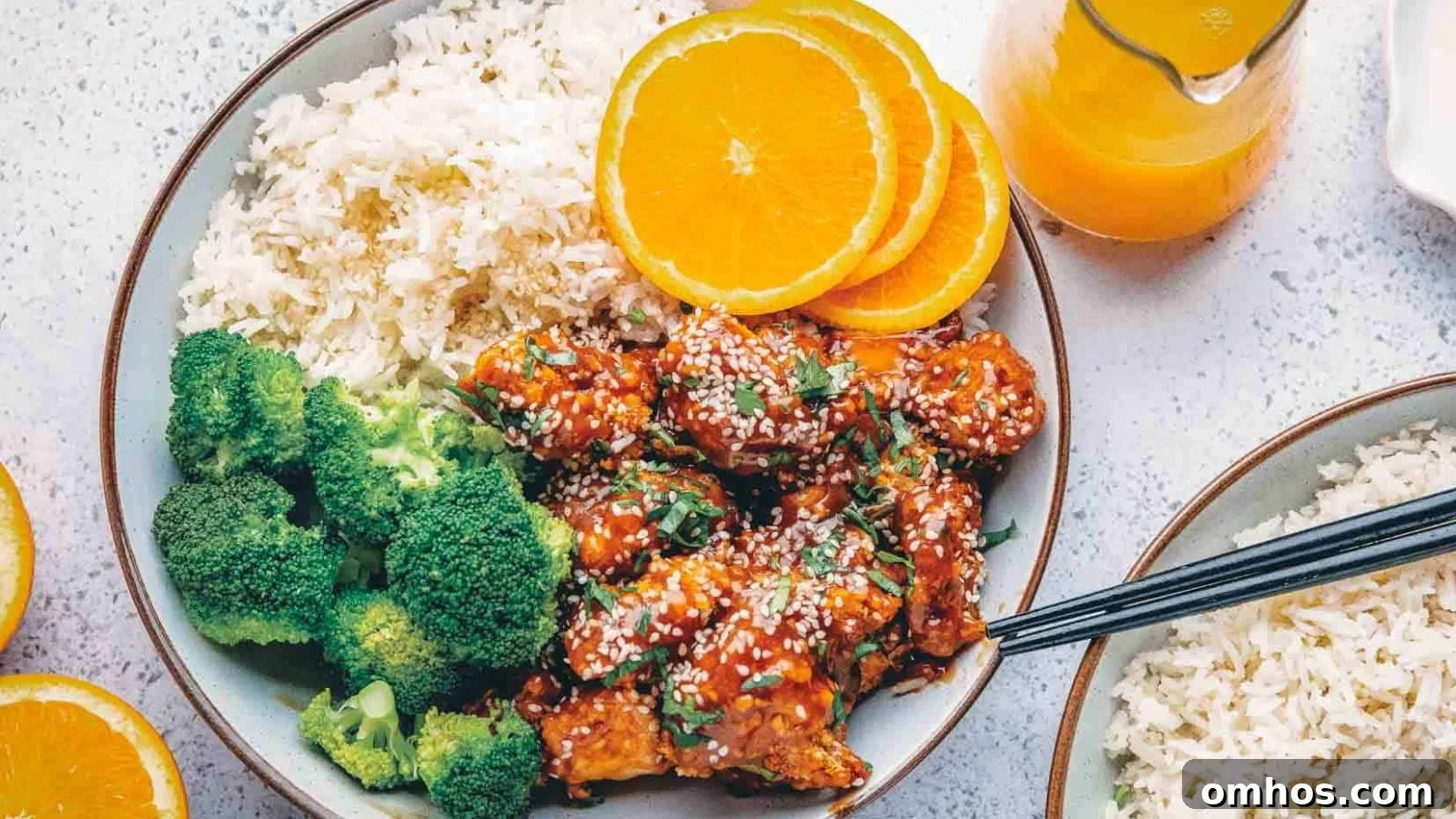 Air fryer orange chicken coated in sticky orange glaze with lightly crisped edges.