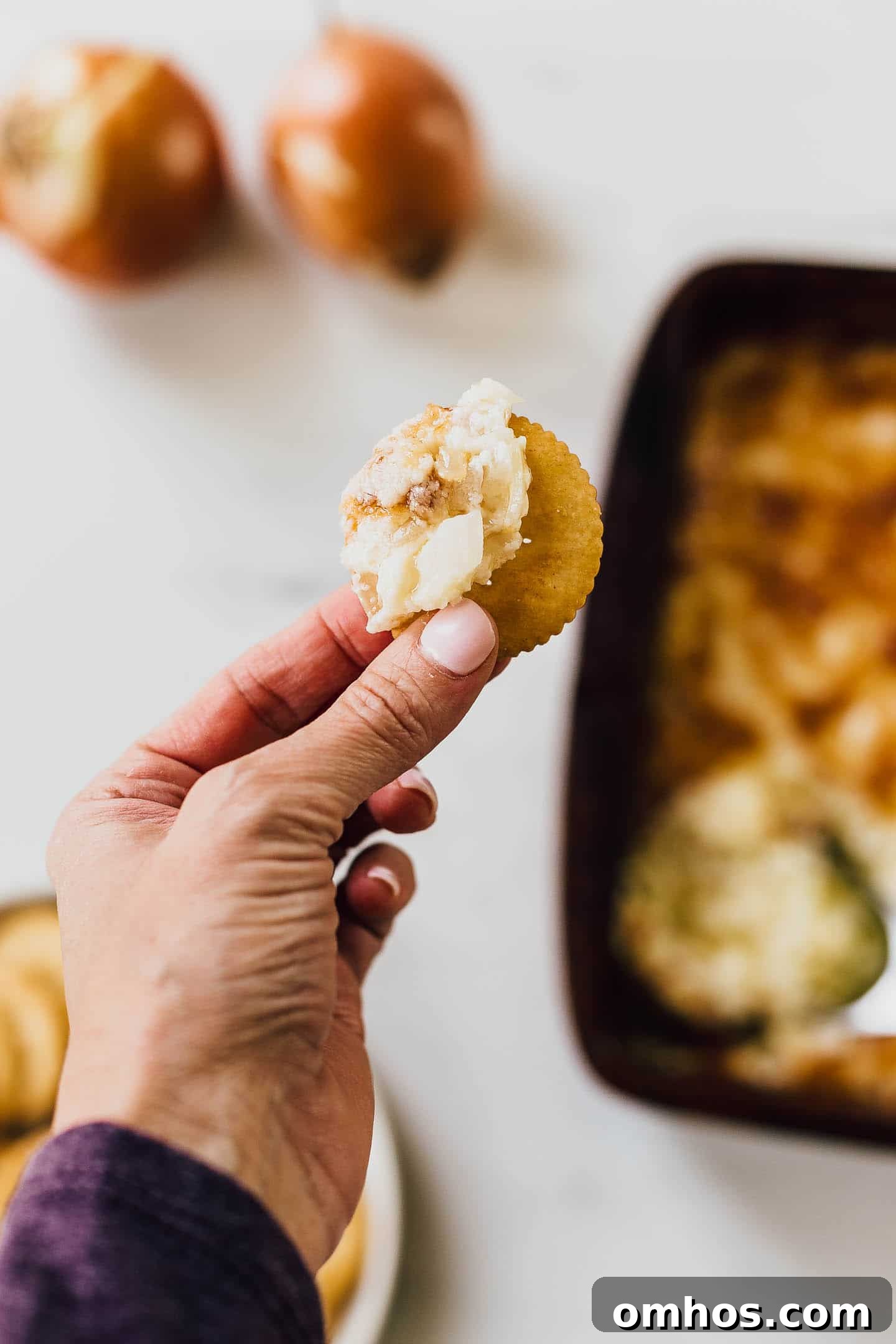 Hot onion dip on a cracker.
