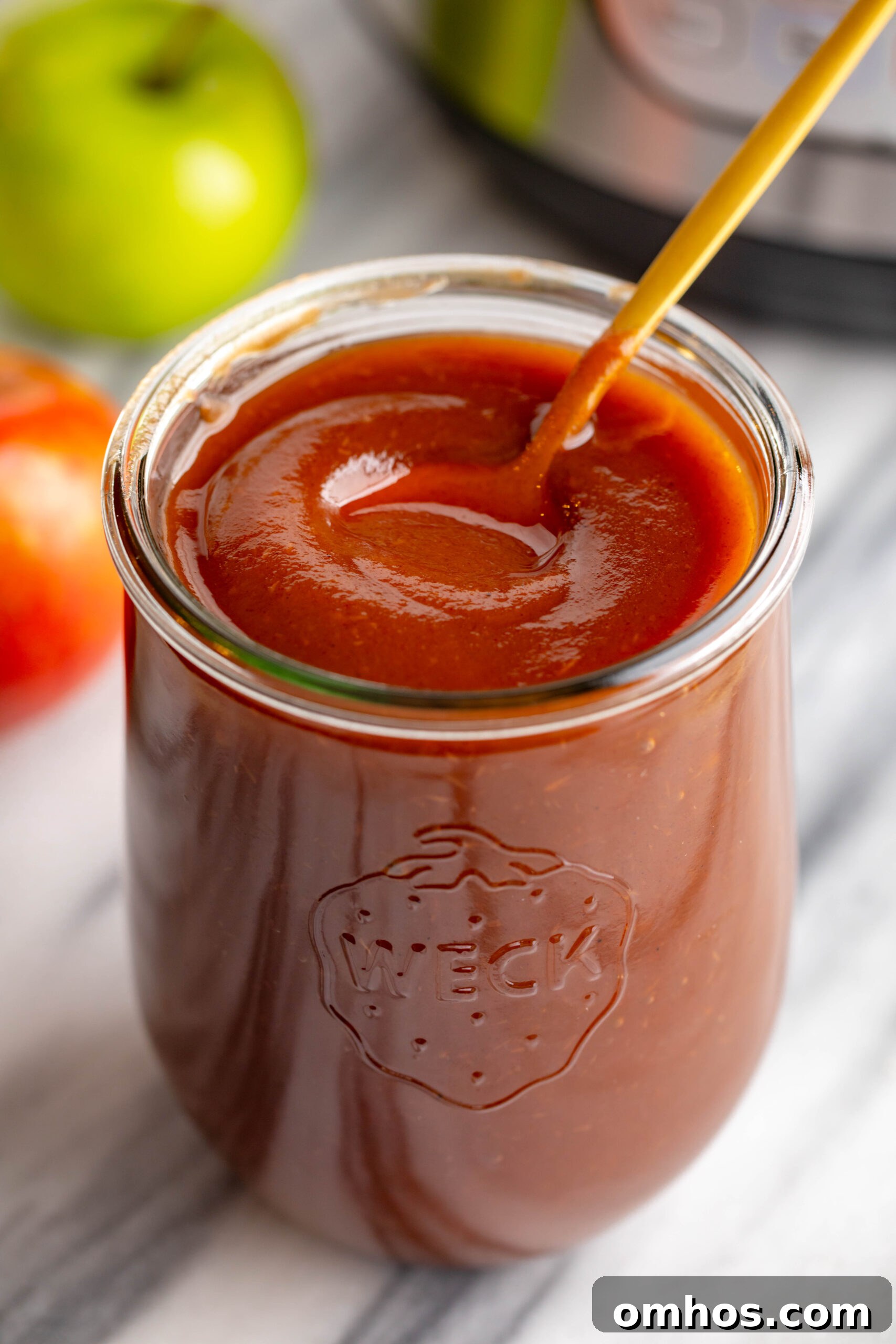 No-Peel Instant Pot Apple Butter Recipe 4 weck jar filled with apple butter and a gold spoon