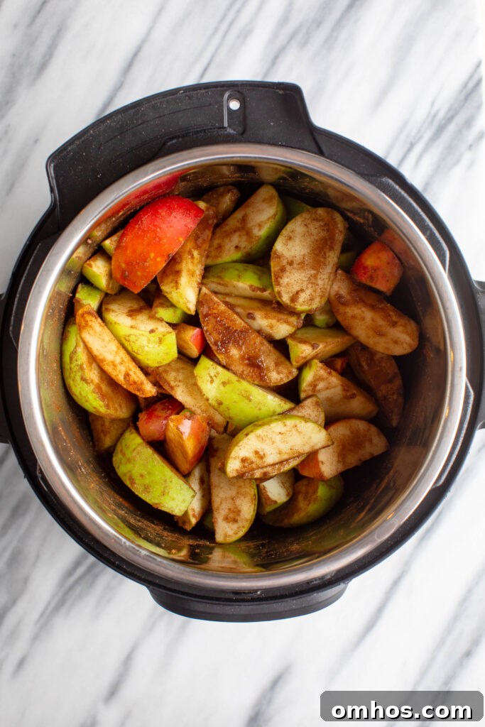 No-Peel Instant Pot Apple Butter Recipe 6 sliced green and red apples mixed with spices in an instapot