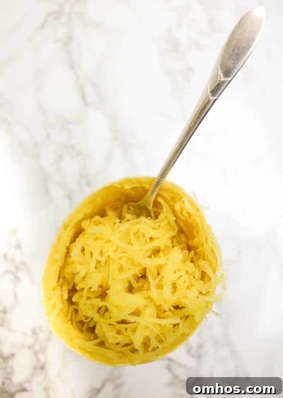 25 Quick Instant Pot Side Dish Recipes for Weeknights 11 Spaghetti squash sitting on a marble table, fork in squash.