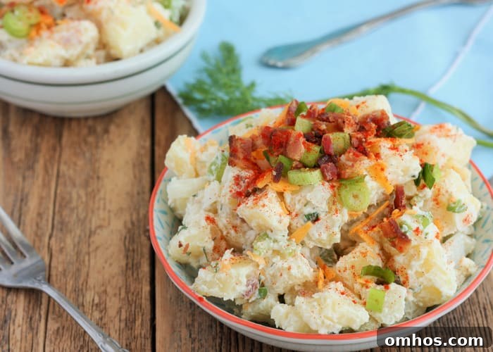 25 Quick Instant Pot Side Dish Recipes for Weeknights 12 Bowl containing potato salad topped with bacon, cheese and scallions, fork on wooden table.