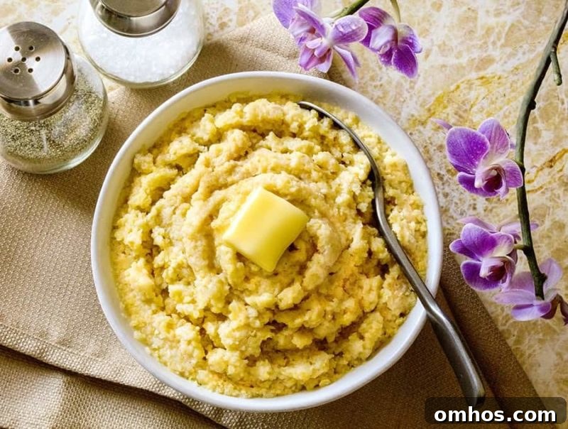 25 Quick Instant Pot Side Dish Recipes for Weeknights 14 White bowl of polenta topped with butter, spoon in bowl.
