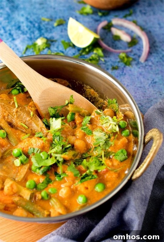 25 Quick Instant Pot Side Dish Recipes for Weeknights 15 Silver bowl filled with Chickpeas and Vegetable Korma, topped with scallions and cilantro.