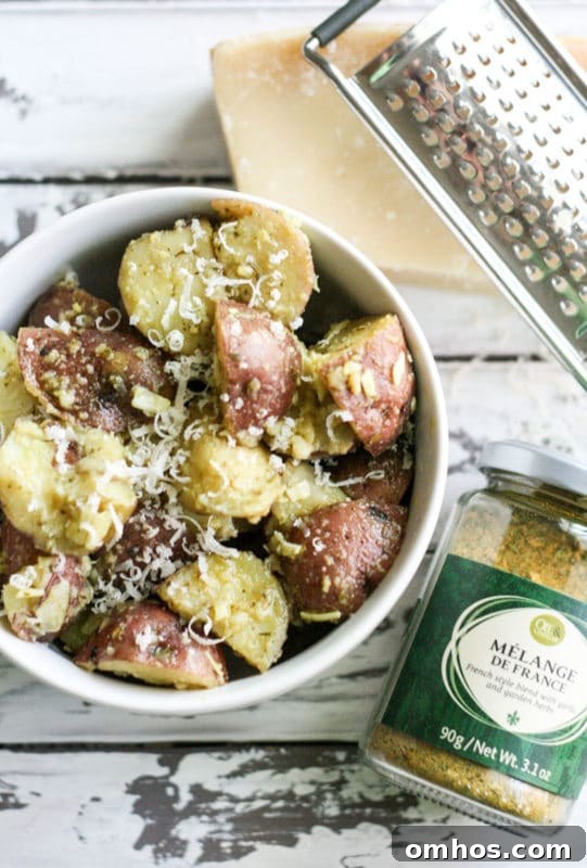 25 Quick Instant Pot Side Dish Recipes for Weeknights 19 White bowl containing potato salad topped with Parmesan Cheese and Melange De France, grater and Parmesan cheese on white table.
