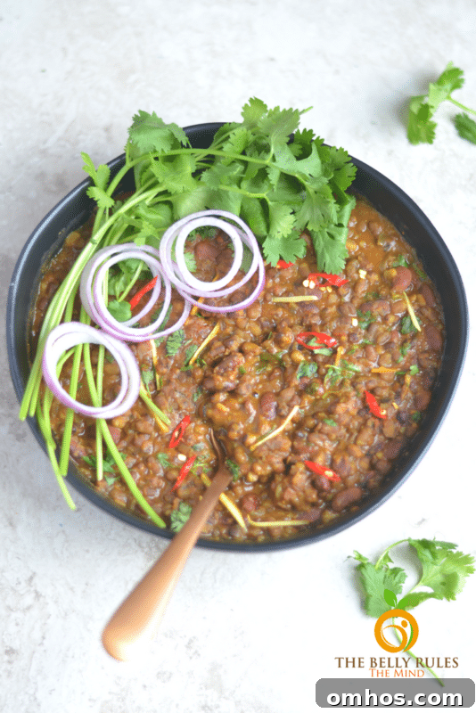 25 Quick Instant Pot Side Dish Recipes for Weeknights 9 Instant Pot Dal Makhani black and kidney bean mix in a black bowl topped with onions and cilantro.