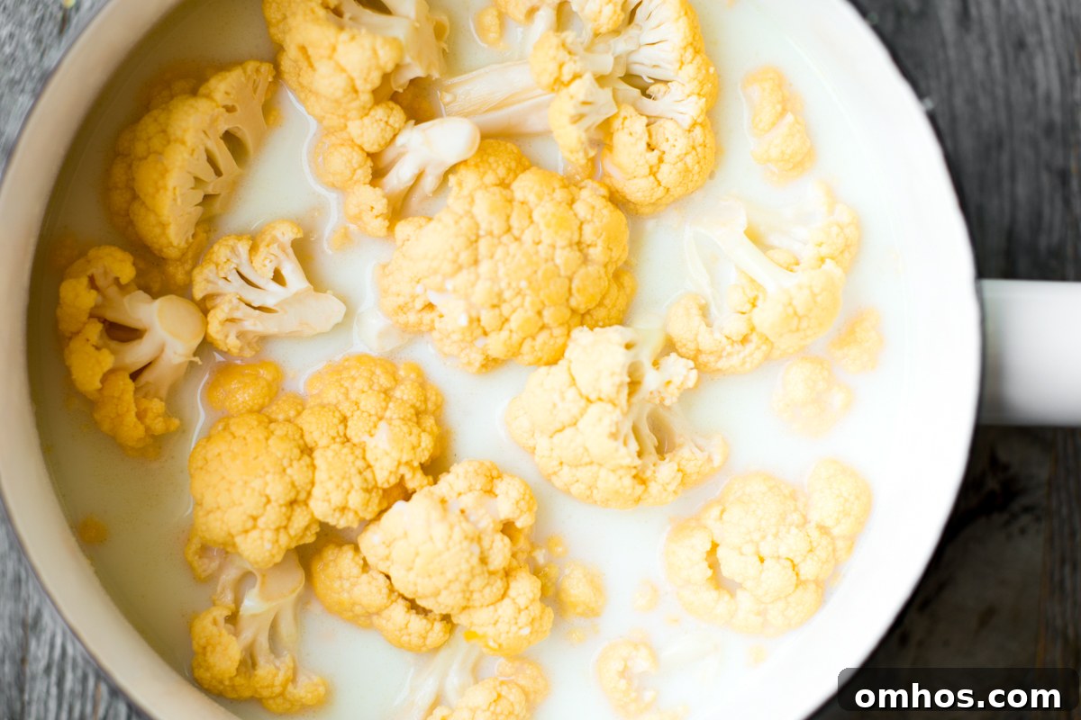 cauliflower simmering in milk in saucepan