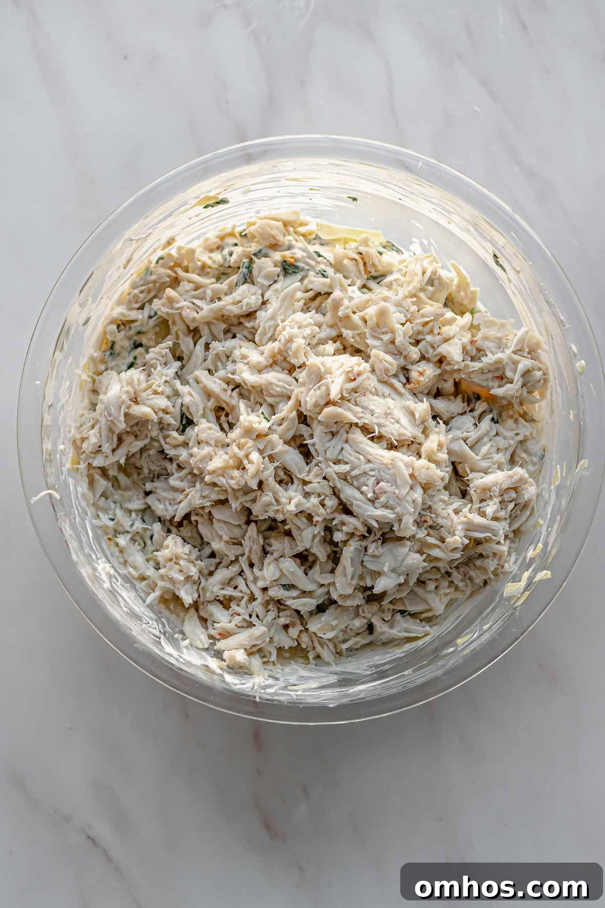 Crab sits on top of spinach artichoke dip.