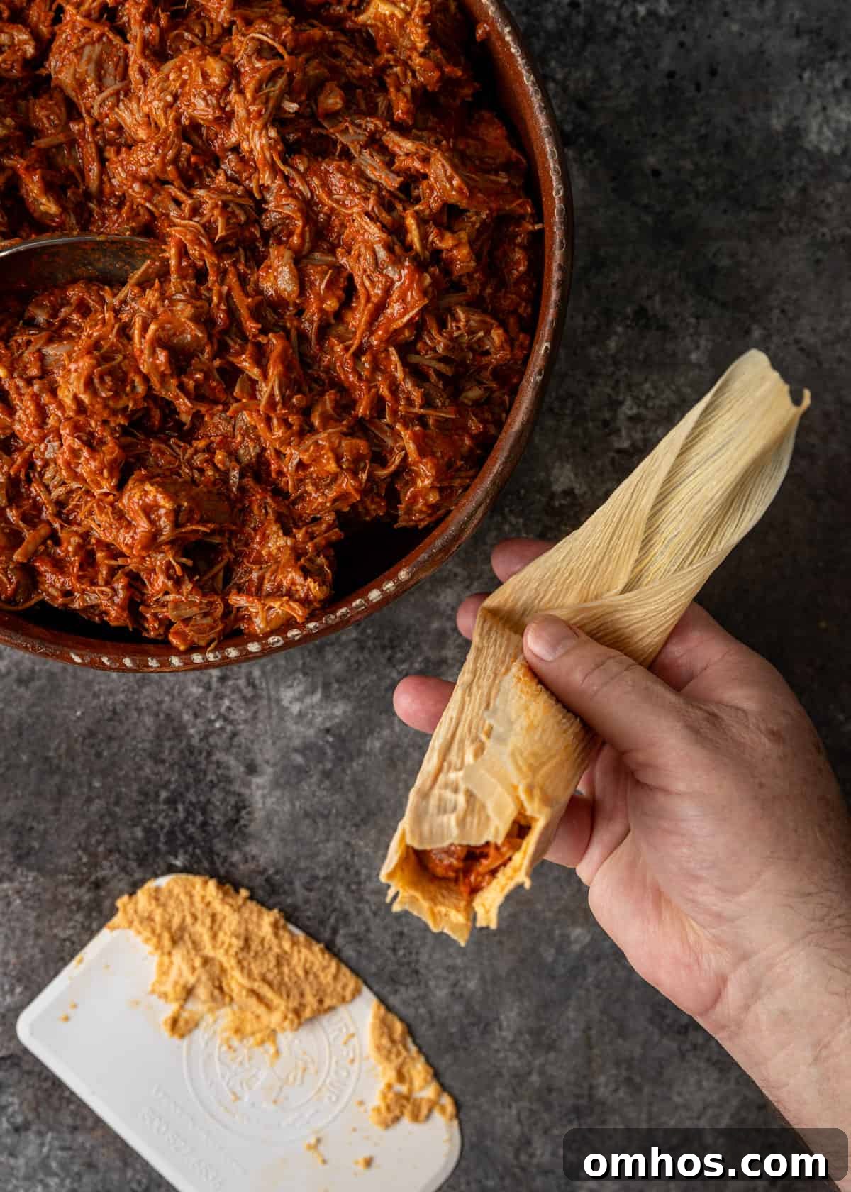 Authentic Mexican Red Pork Tamales Recipe 10 overhead process shot: titled image (and shown) bend lower tip end