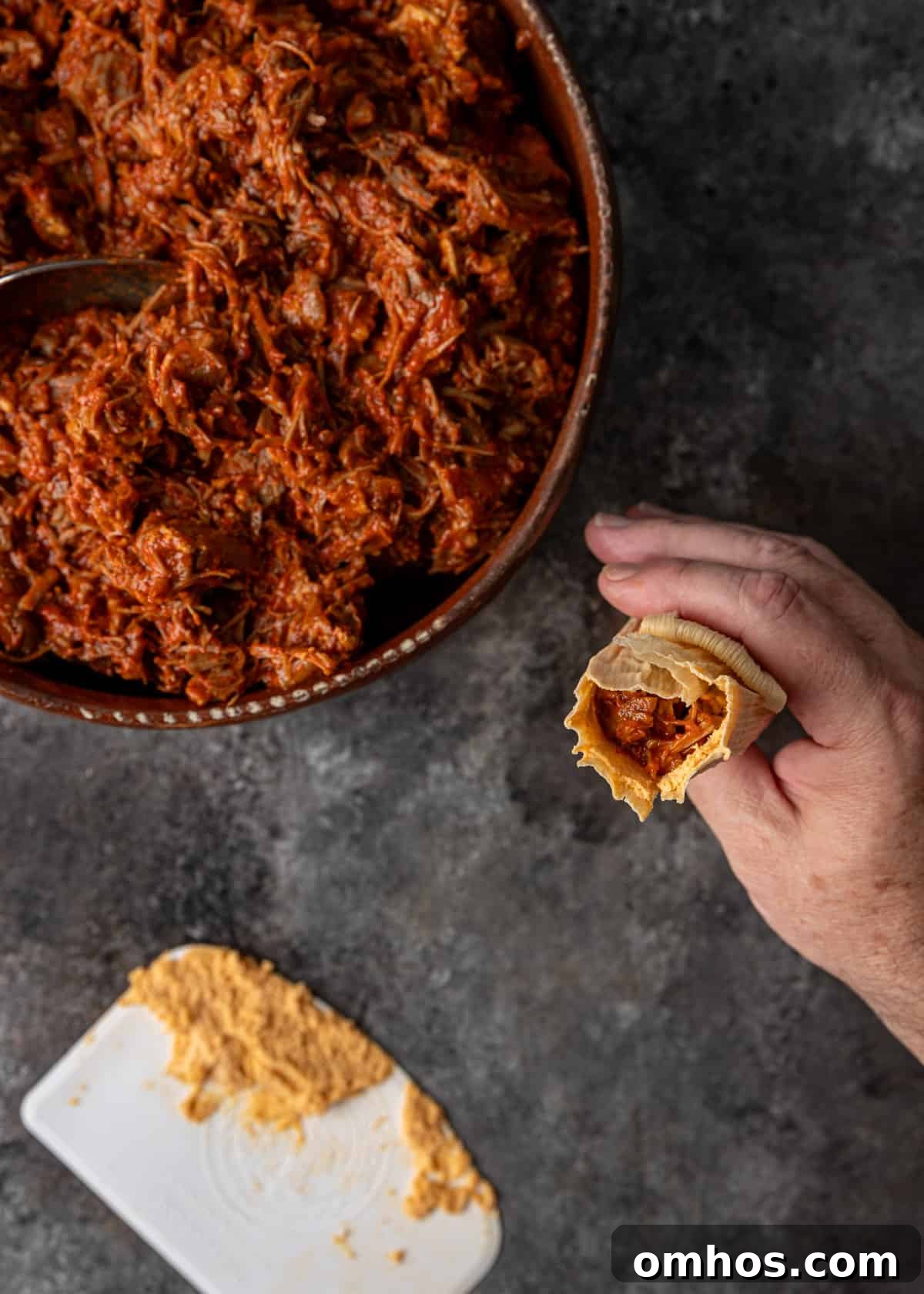 Authentic Mexican Red Pork Tamales Recipe 11 overhead process shot: titled image (and shown) fold tip to top