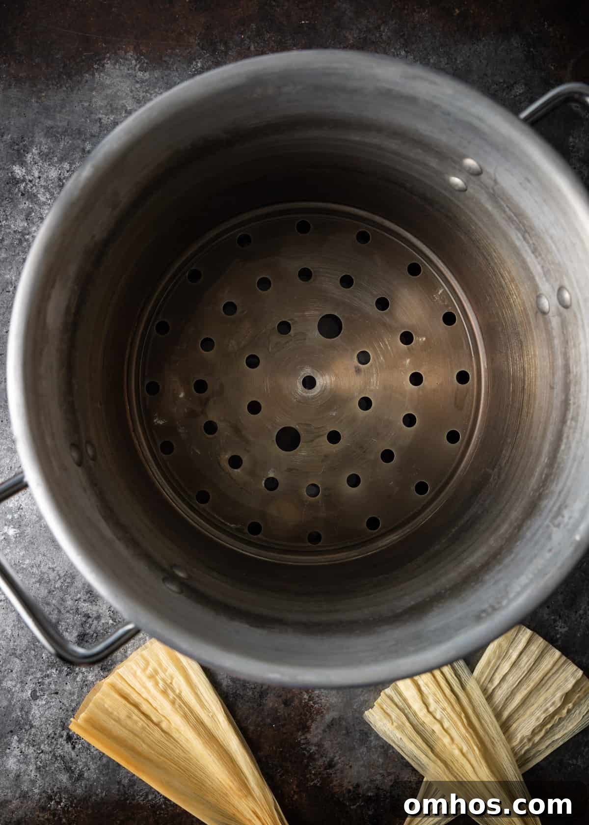 Authentic Mexican Red Pork Tamales Recipe 14 overhead process shot: titled image (and shown) fill bottom of steamer with water