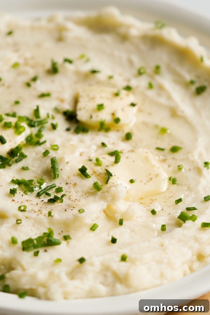 close up shot of potatoes topped with fresh chives and butter