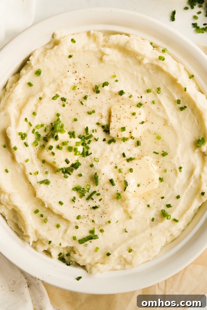 overhead shot of mashed potatoes topped with truffle oil, fresh chives, butter, and pepper